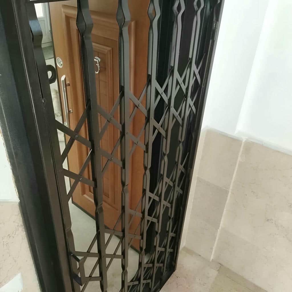 حفاظ درب آکاردئونی مشکی کنار ورودی آفتاب گیر اصفهان