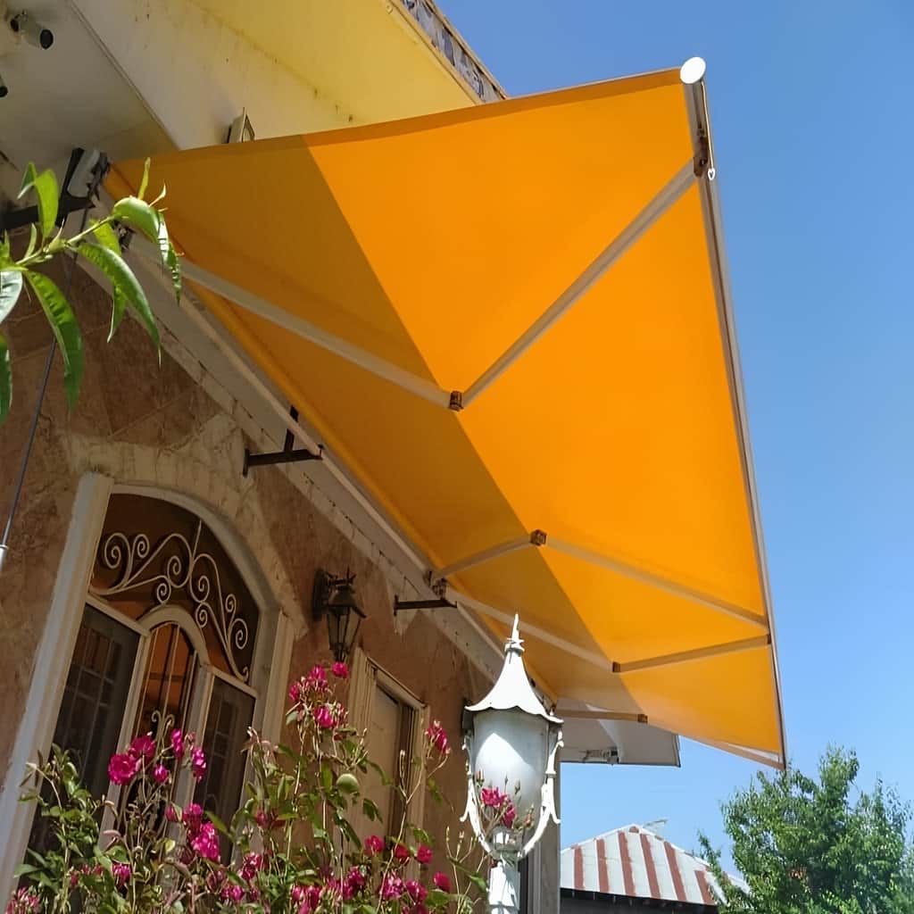 سایبان برقی با پارچه راه راه روی حیاط آجری