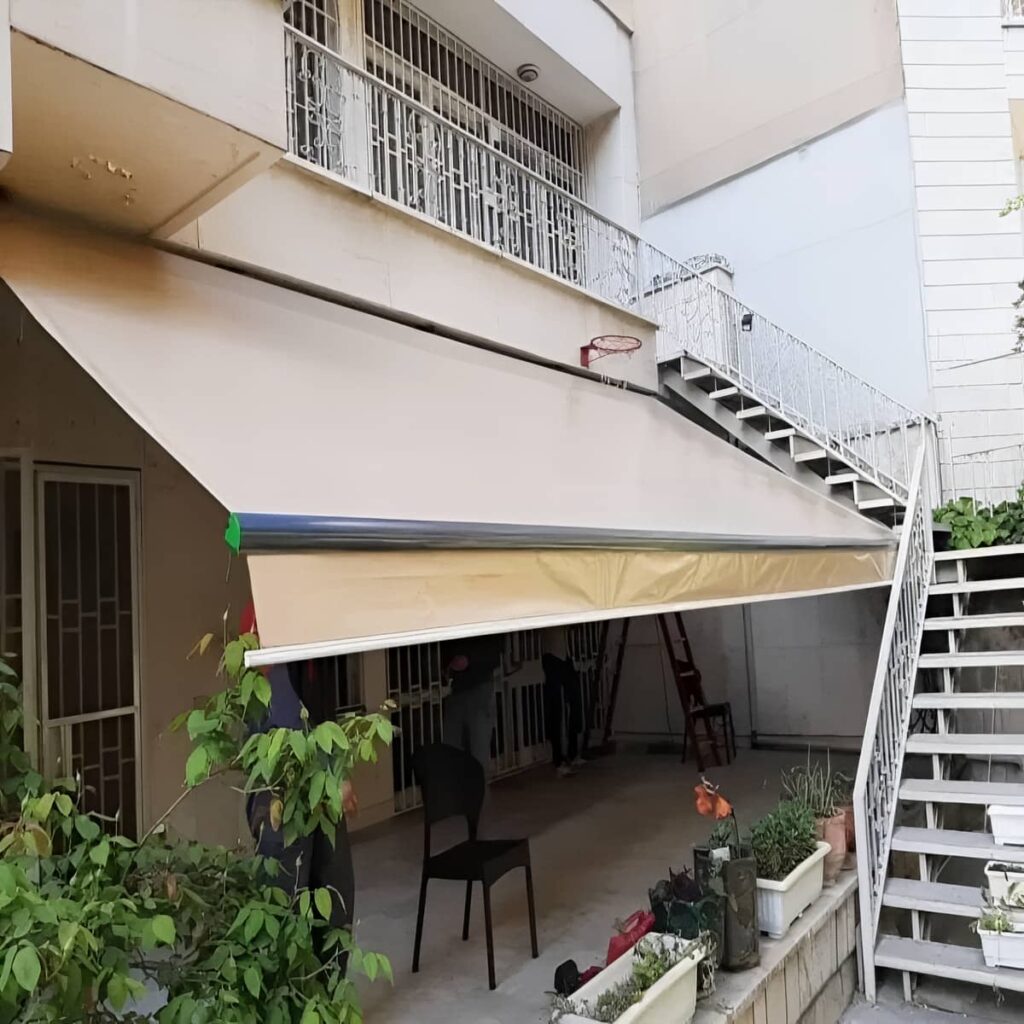 سایبان برقی خاکستری جمع شده زیر تابلوی داروخانه