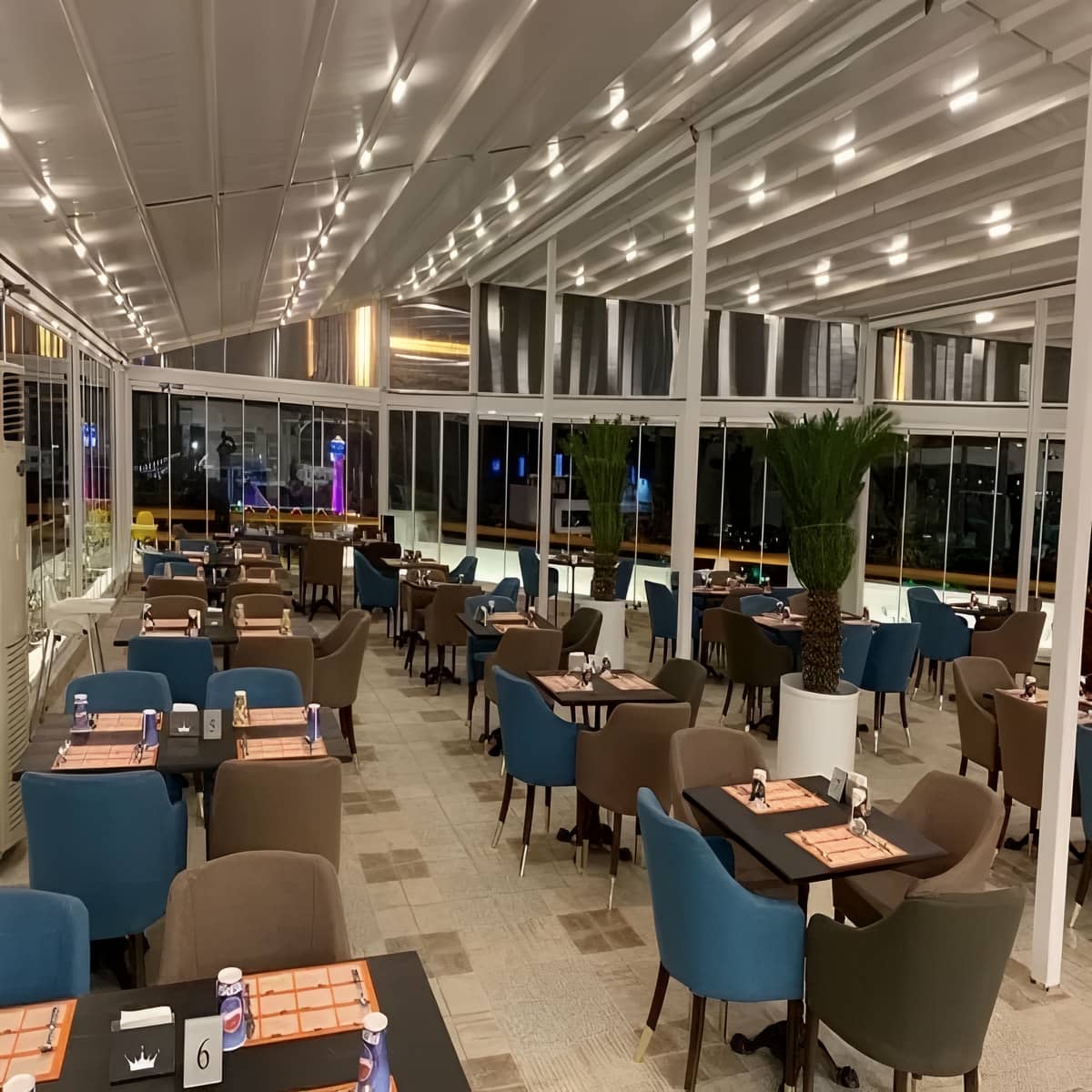 سایبان برقی خاکستری روی نمای شیشه‌ای شوروم استان خوزستان