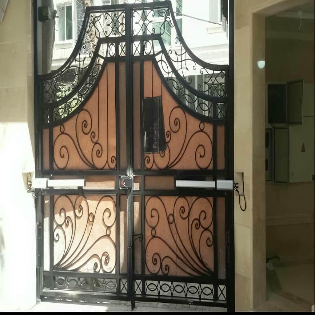 نمای نزدیک بازوی خاکستری روی دروازه مشکی نمای نزدیک بازوی خاکستری روی دروازه مشکی